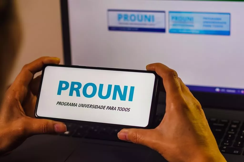 moça segurando celular com app do prouni